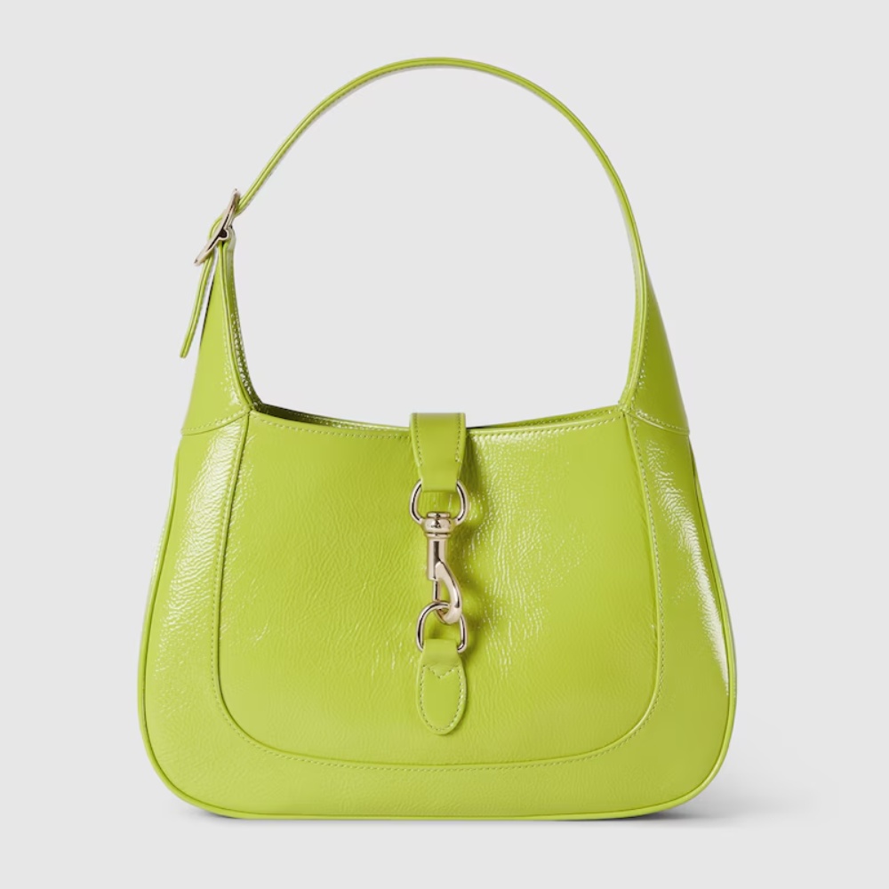 Lime green leather handbag with silver hardware and a singular shoulder strap, isolated on a white background.